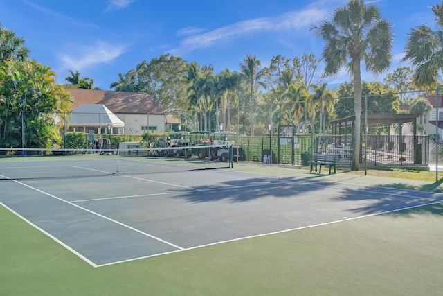 view of tennis court with community basketball court and fence