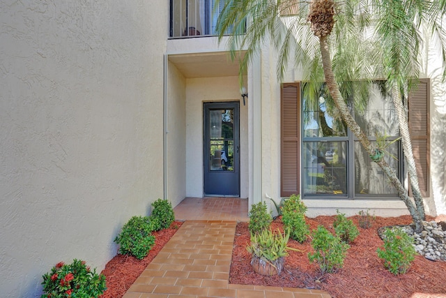 doorway to property with a balcony and stucco siding