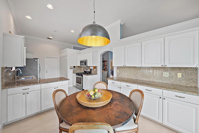 kitchen featuring white cabinetry, a sink, crown molding, and appliances with stainless steel finishes