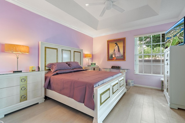 bedroom featuring crown molding, baseboards, ceiling fan, a raised ceiling, and light wood-style floors