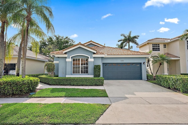 mediterranean / spanish home featuring a tiled roof, concrete driveway, stucco siding, and an attached garage