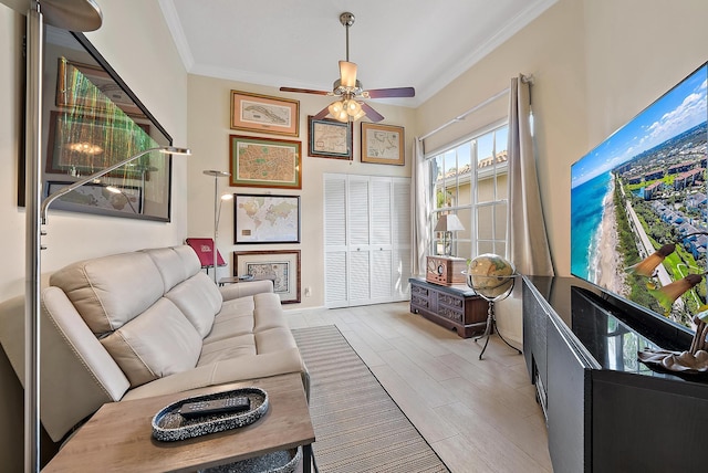living area featuring wood tiled floor, crown molding, and a ceiling fan