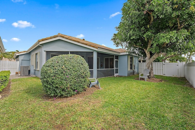 back of property with a fenced backyard, a tile roof, and stucco siding