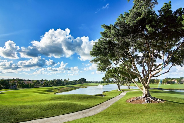 surrounding community featuring golf course view, a water view, and a lawn