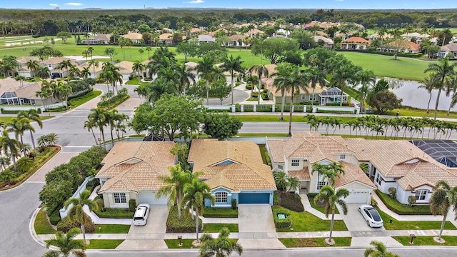 bird's eye view featuring golf course view, a water view, and a residential view