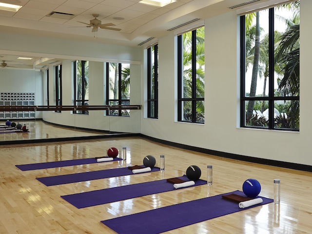 gym featuring a healthy amount of sunlight, visible vents, a paneled ceiling, and a ceiling fan