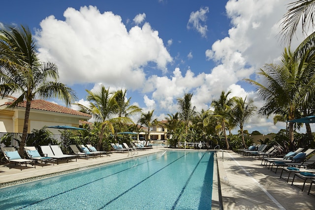 community pool with fence and a patio area