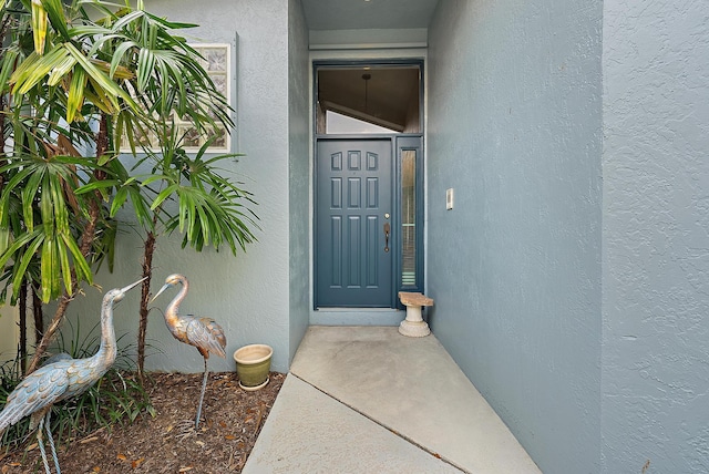doorway to property featuring stucco siding