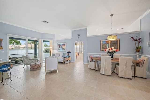 dining area featuring crown molding, baseboards, light tile patterned flooring, arched walkways, and visible vents