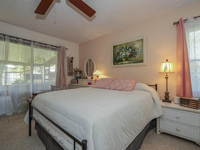 bedroom with light colored carpet and a ceiling fan