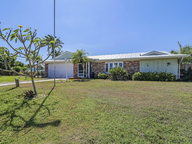 view of front facade with a front yard, an attached garage, brick siding, and driveway