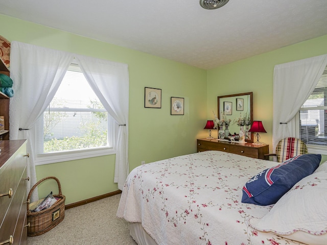 carpeted bedroom with multiple windows and baseboards