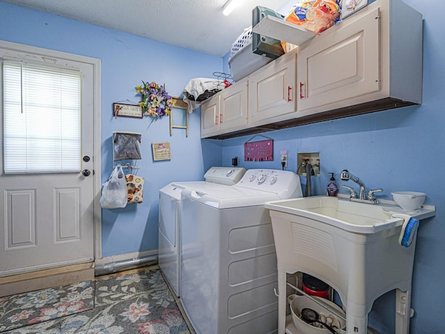 washroom featuring cabinet space, washer and dryer, baseboards, and a sink