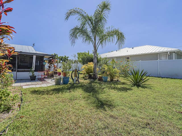 view of yard featuring a sunroom, a patio, and fence