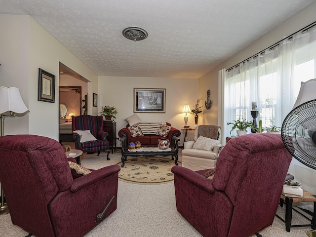 living room with carpet, visible vents, and a textured ceiling