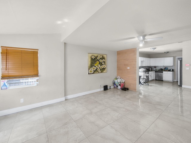 unfurnished living room featuring baseboards and a ceiling fan