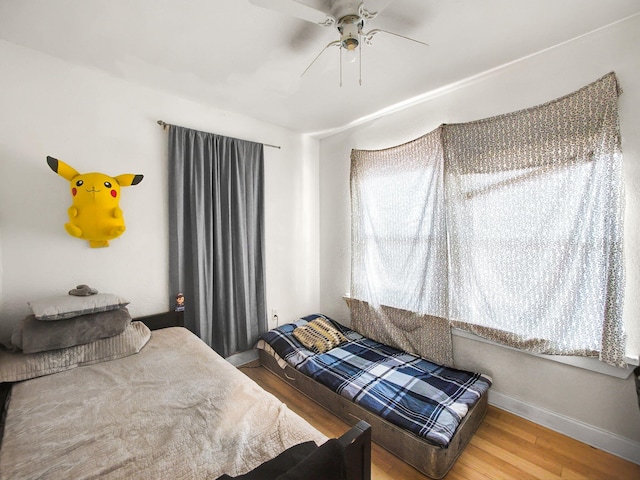 bedroom with baseboards, wood finished floors, and ceiling fan