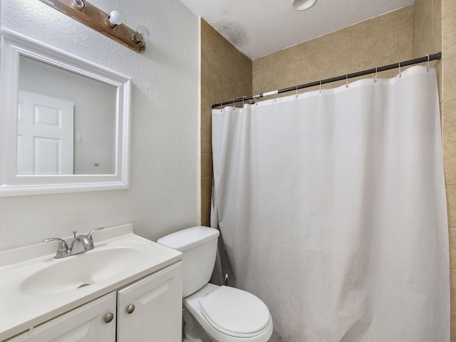 full bathroom with a textured ceiling, a textured wall, a shower with shower curtain, toilet, and vanity