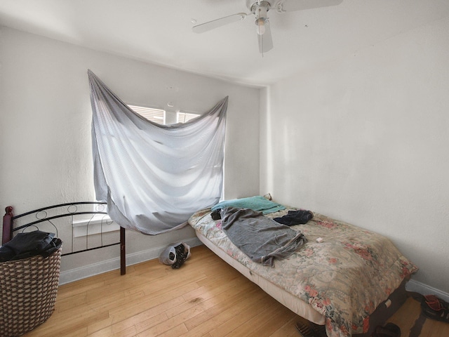 bedroom with baseboards, wood finished floors, and a ceiling fan