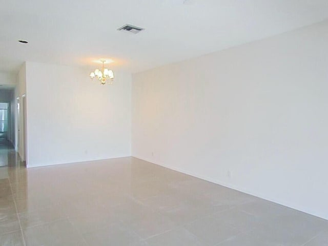 unfurnished room featuring light tile patterned floors, visible vents, and an inviting chandelier