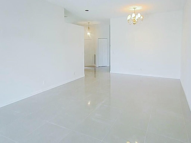 unfurnished room featuring light tile patterned floors and a notable chandelier