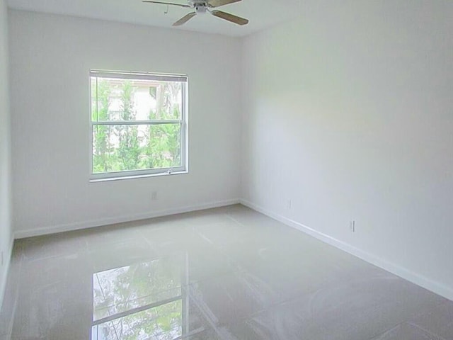 spare room with baseboards and ceiling fan