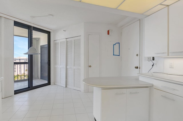 4545 N Ocean Blvd Unit 10C, Boca Raton, FL 33431 - kitchen with light countertops, white cabinets, expansive windows, light tile patterned floors, and a peninsula