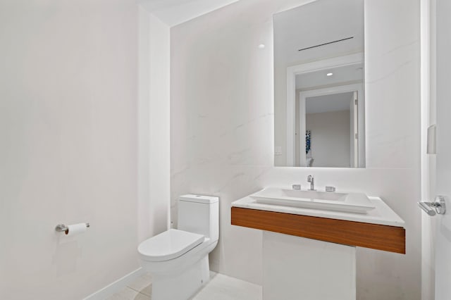 bathroom featuring tile patterned floors, toilet, and a sink