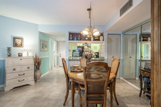 dining space with visible vents, baseboards, an inviting chandelier, light tile patterned flooring, and a textured ceiling