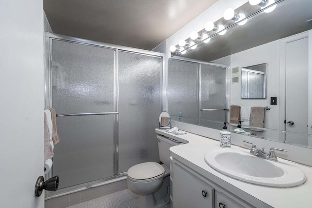 bathroom with tile patterned floors, toilet, a stall shower, and vanity