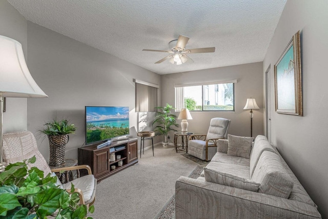 carpeted living area featuring a ceiling fan and a textured ceiling