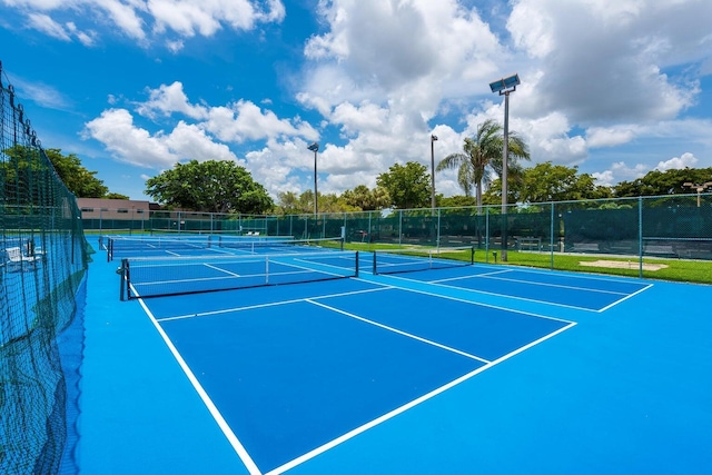 view of tennis court with community basketball court and fence