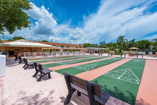 view of home's community with shuffleboard and fence