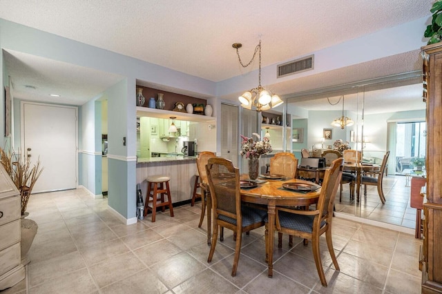 dining room with visible vents, a textured ceiling, an inviting chandelier, and light tile patterned flooring