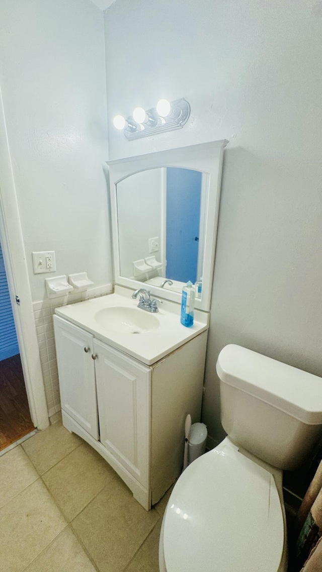 bathroom featuring tile patterned flooring, toilet, and vanity