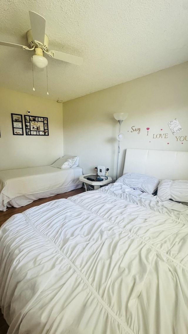 bedroom with a textured ceiling and a ceiling fan