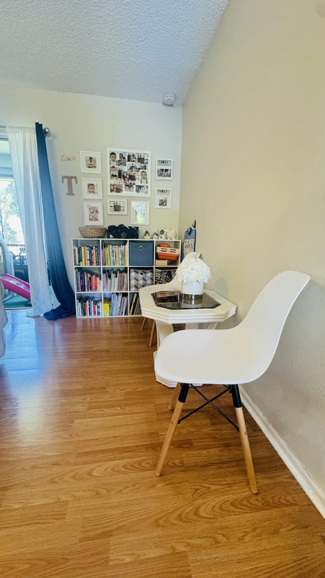 dining area featuring a textured ceiling and wood finished floors