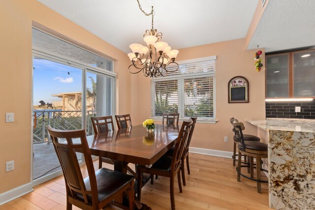 309 E Ocean Ave Unit 103, Lantana, FL 33462 - dining area featuring a notable chandelier, baseboards, and light wood finished floors