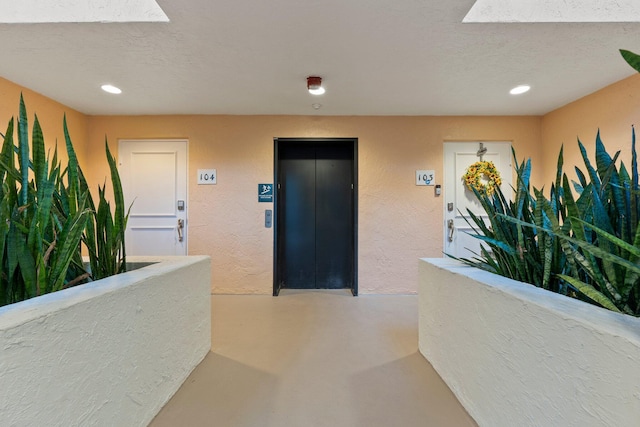 309 E Ocean Ave Unit 103, Lantana, FL 33462 - hall featuring recessed lighting, a textured wall, finished concrete floors, a textured ceiling, and elevator