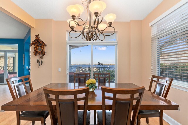 309 E Ocean Ave Unit 103, Lantana, FL 33462 - dining area with a notable chandelier, baseboards, and wood finished floors