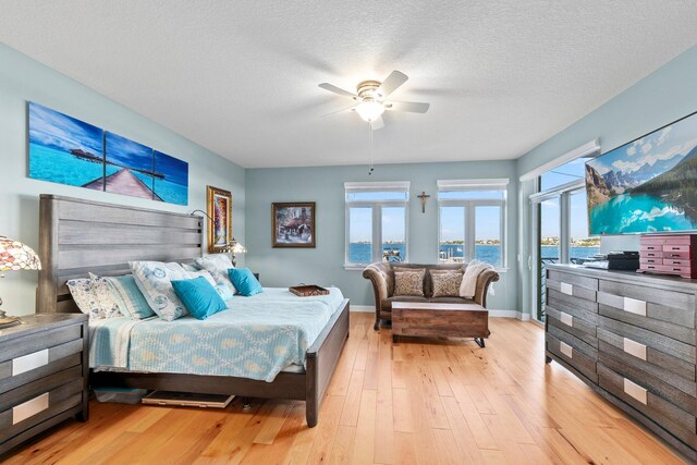 309 E Ocean Ave Unit 103, Lantana, FL 33462 - bedroom featuring baseboards, a textured ceiling, a ceiling fan, and hardwood / wood-style flooring