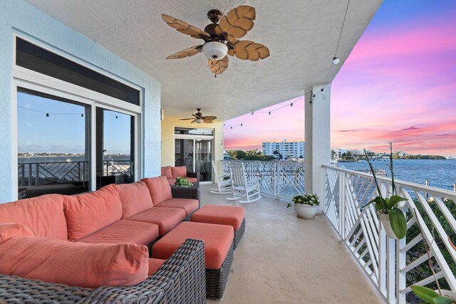 309 E Ocean Ave Unit 103, Lantana, FL 33462 - balcony at dusk with outdoor lounge area, a water view, and a ceiling fan