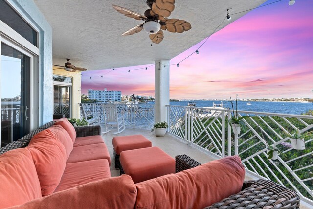 309 E Ocean Ave Unit 103, Lantana, FL 33462 - balcony at dusk featuring an outdoor living space, a water view, and ceiling fan