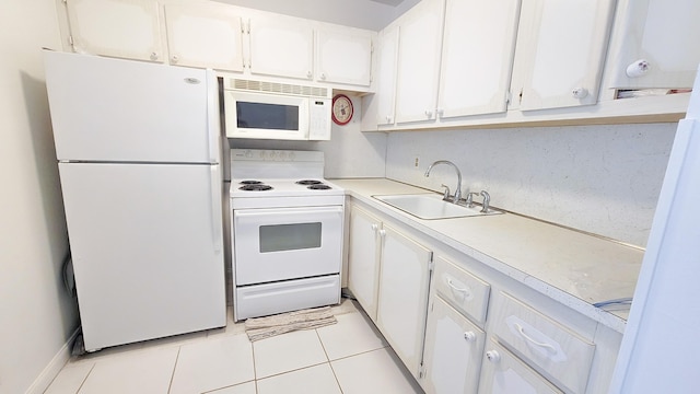 kitchen with white appliances, light countertops, white cabinets, a sink, and light tile patterned flooring