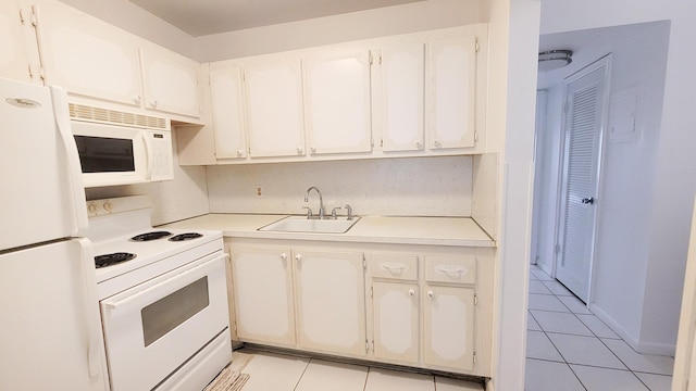 kitchen featuring light tile patterned floors, white cabinets, a sink, light countertops, and white appliances