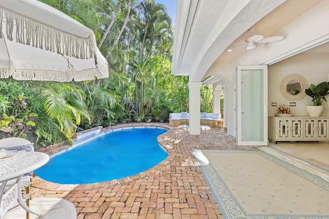 pool with a patio area, an outdoor hangout area, and a ceiling fan