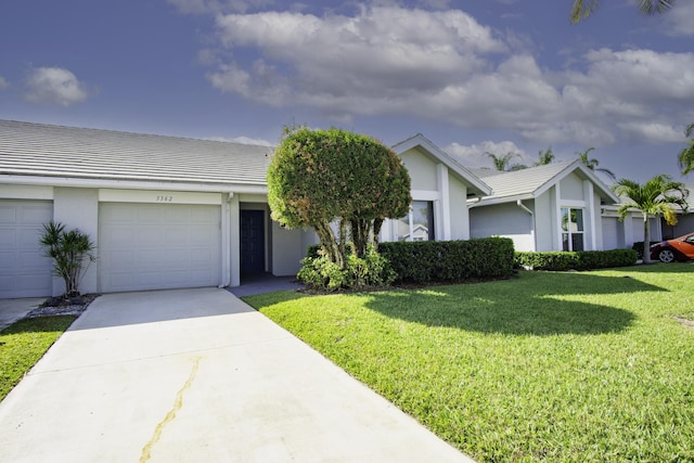 view of front of home featuring a garage, stucco siding, concrete driveway, and a front yard