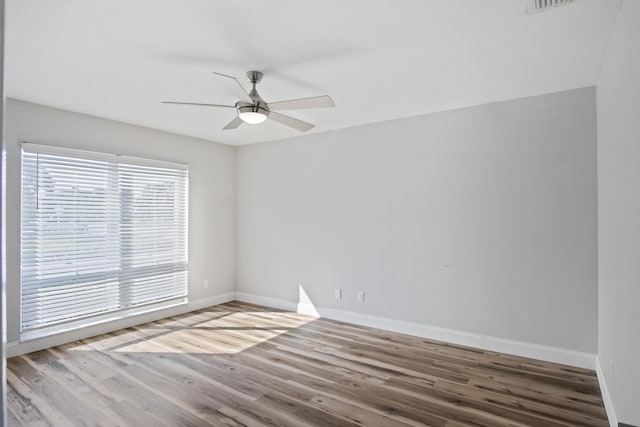 unfurnished room with ceiling fan, baseboards, and wood finished floors