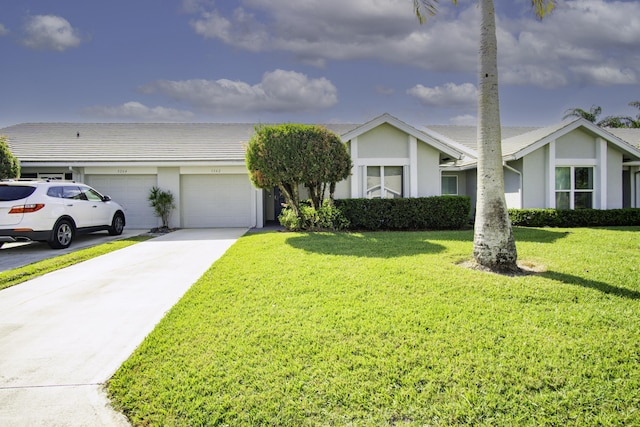 view of front facade featuring stucco siding, a garage, concrete driveway, and a front yard