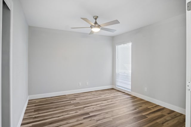 spare room with wood finished floors, baseboards, and ceiling fan